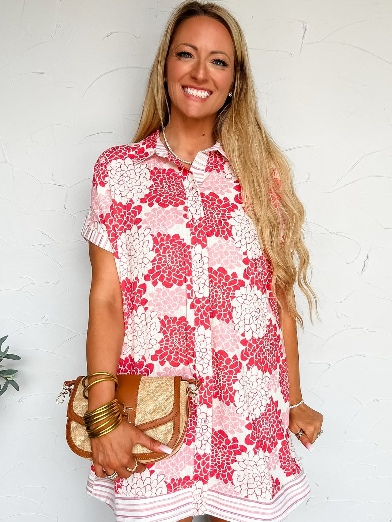Woman wearing a red and white floral dress against a white background