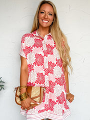 Woman wearing a red and white floral dress against a white background