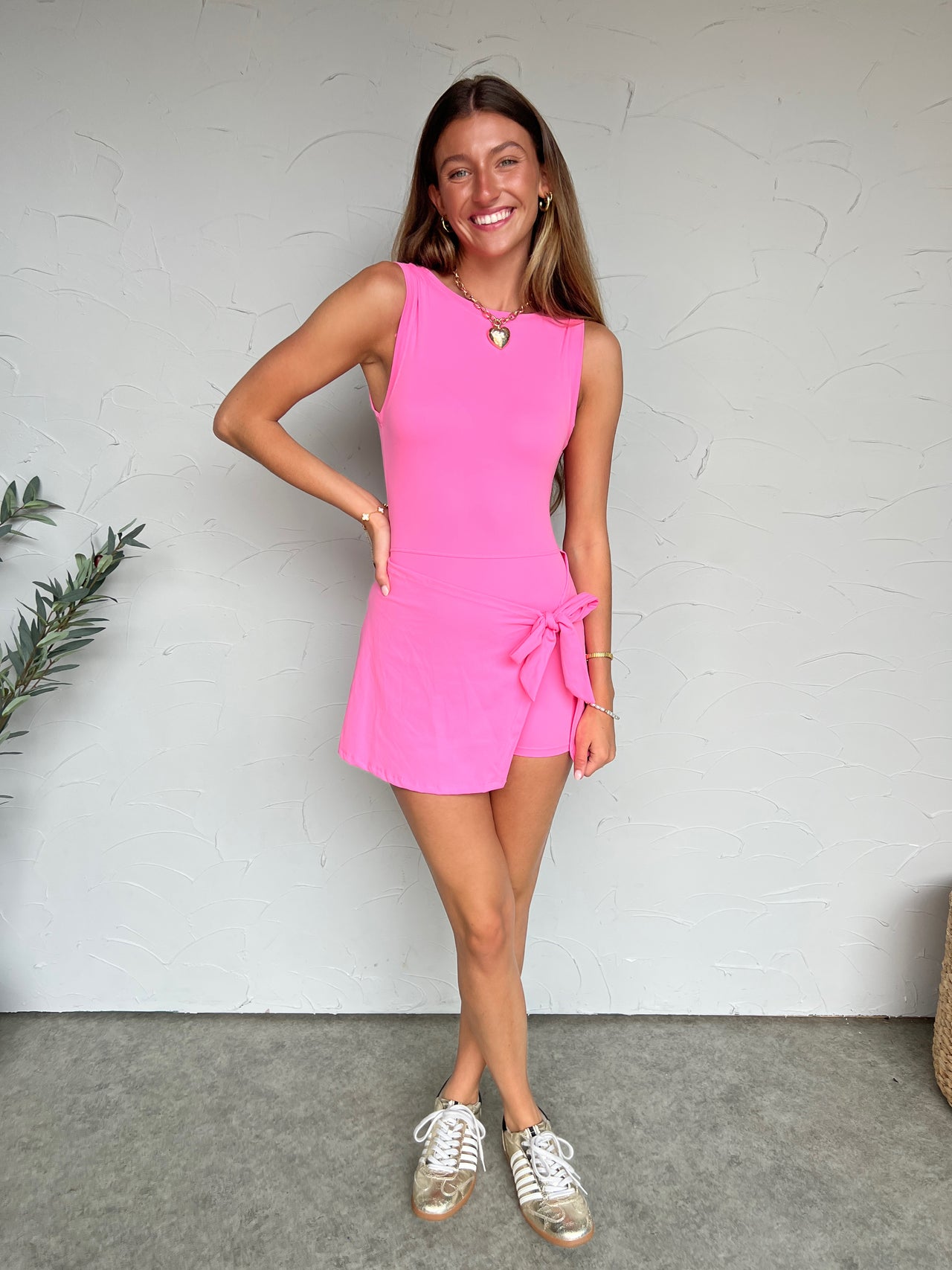 Girl in athletic dress in front of plain wall 