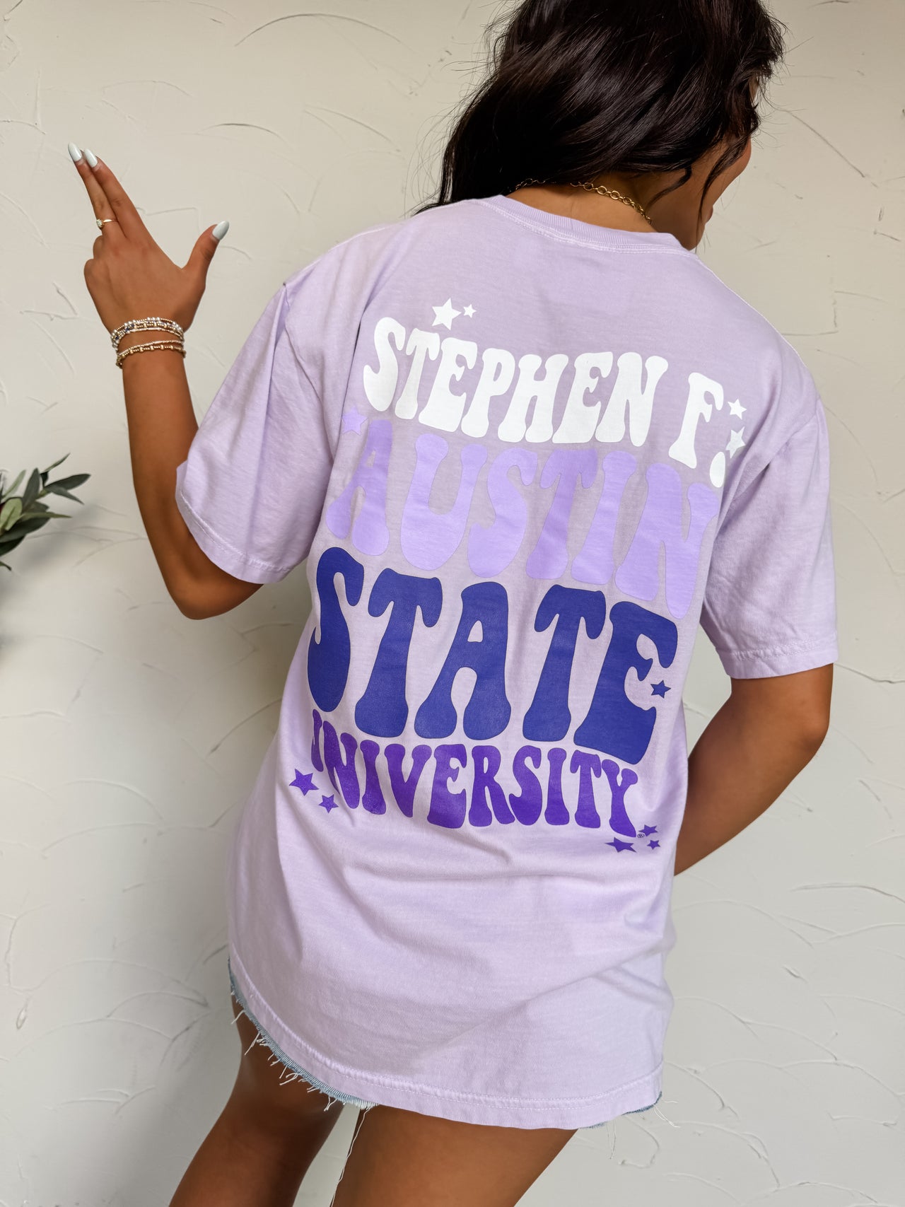 Person wearing a light purple t-shirt with 'Stephen F. Austin State University' printed on the back.
