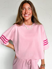 woman wearing a pink top and pant lounge set with hot pink detailing