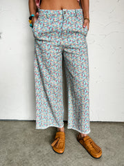 Person wearing floral patterned pants with a white background
