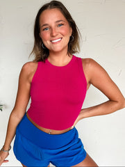 women wearing a ribbed pink tank top with blue shorts
