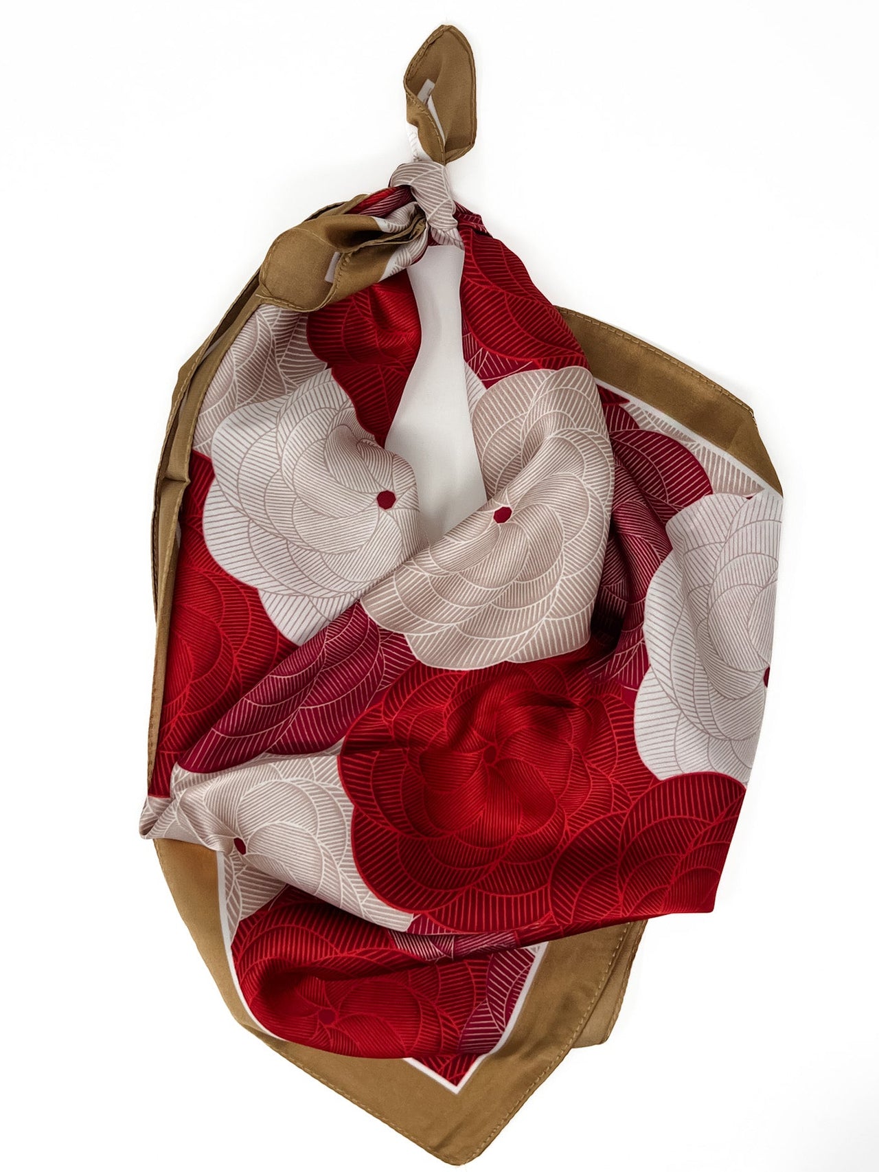 Red, white and brown floral patterned scarf tied on a white background