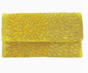 Yellow clutch beaded bag with intricate beaded design on a white background