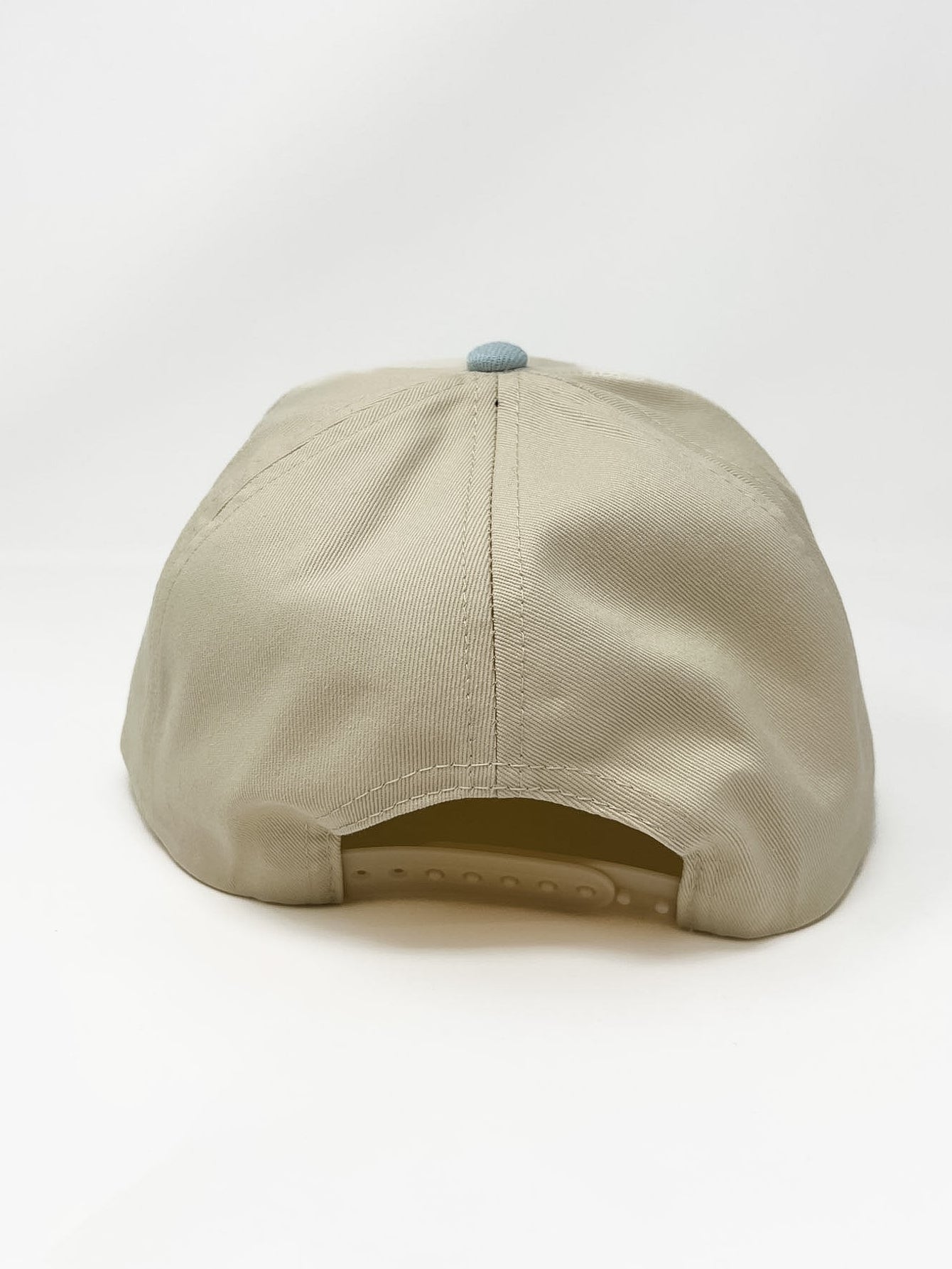 Cream and light blue two-tone baseball cap with raised “faithful” embroidery on the front.