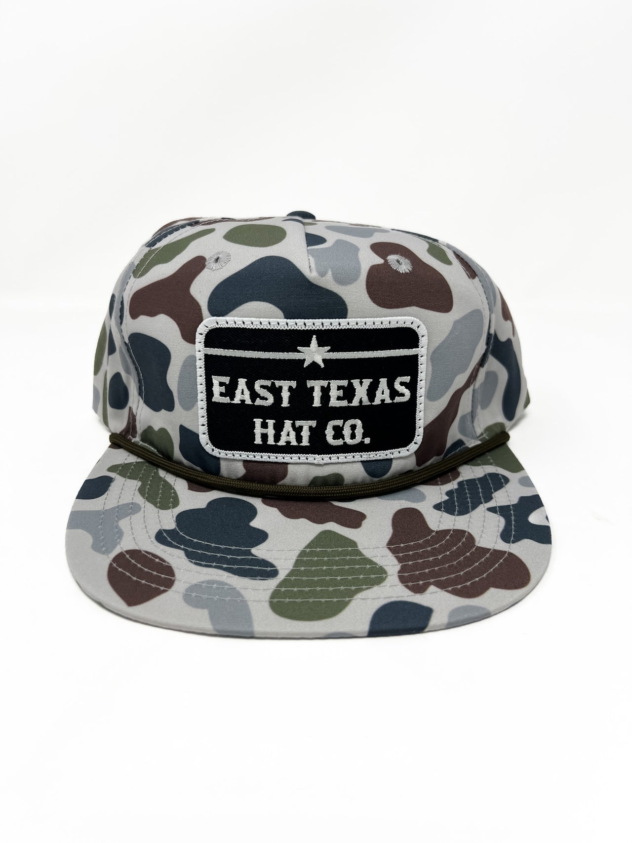 Camouflage-patterned cap with 'East Texas Hat Co.' patch on a white background