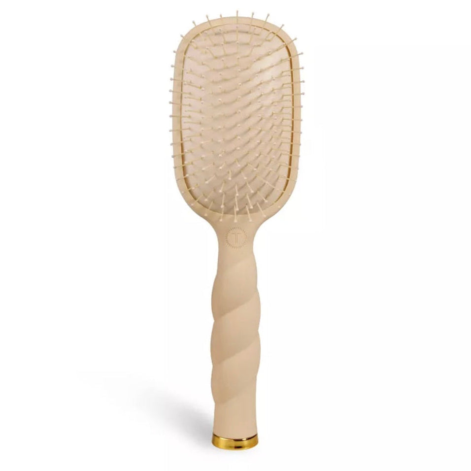 Beige hairbrush with gold accents on a white background