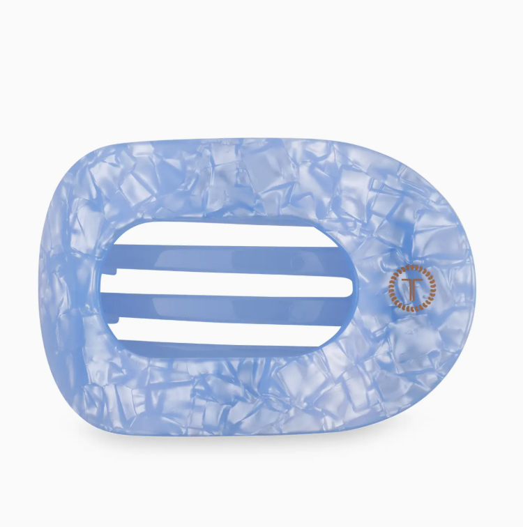 Blue marbled hair clip with a white center on a white background