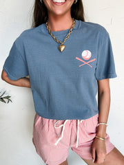 Person wearing a blue t-shirt with a pink baseball logo and red striped shorts on a white background