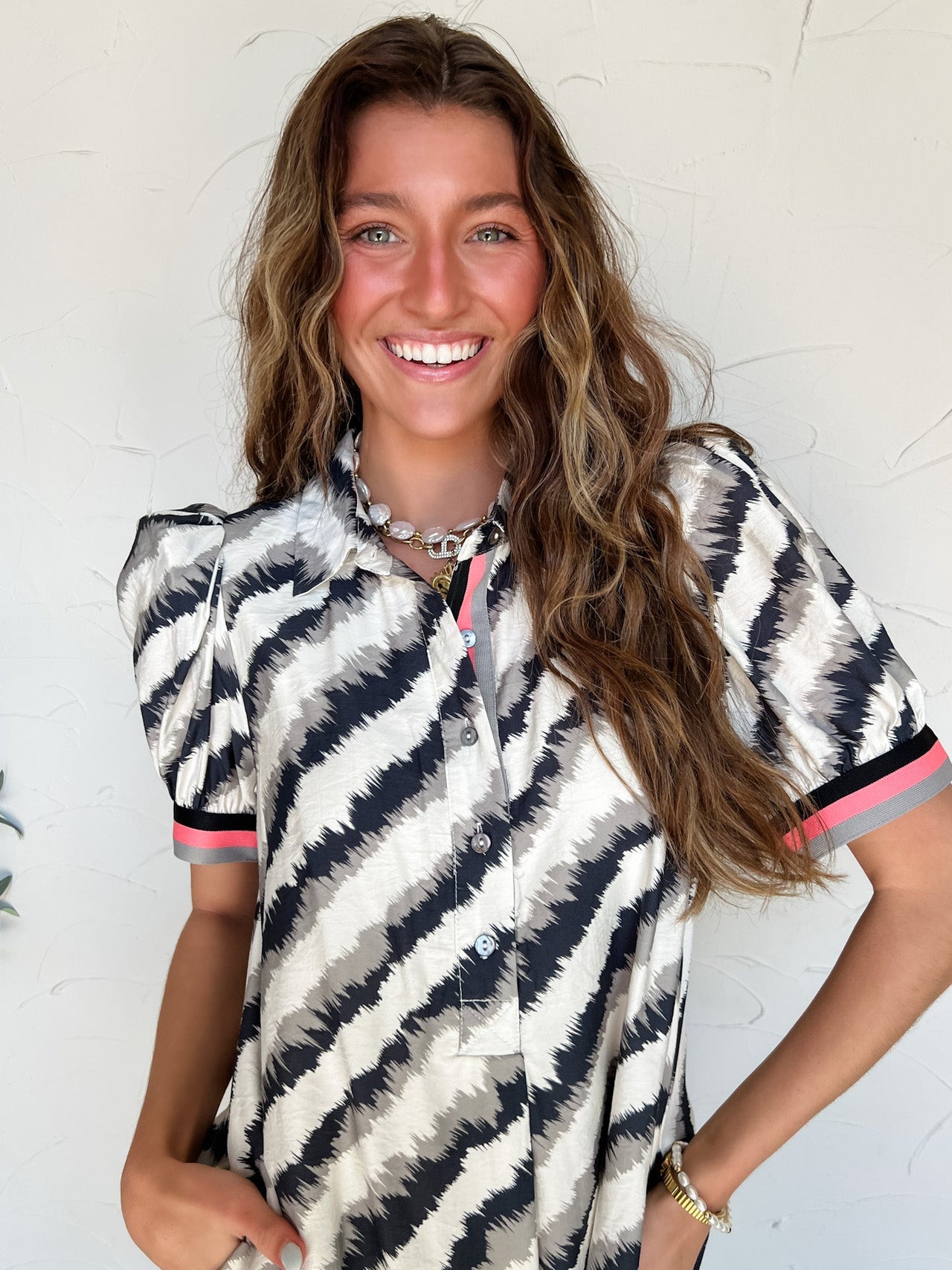 a woman wearing a black and white abstract stripe pattern dress with pockets and striped detail on sleeves