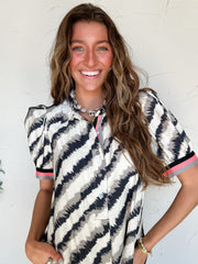 a woman wearing a black and white abstract stripe pattern dress with pockets and striped detail on sleeves