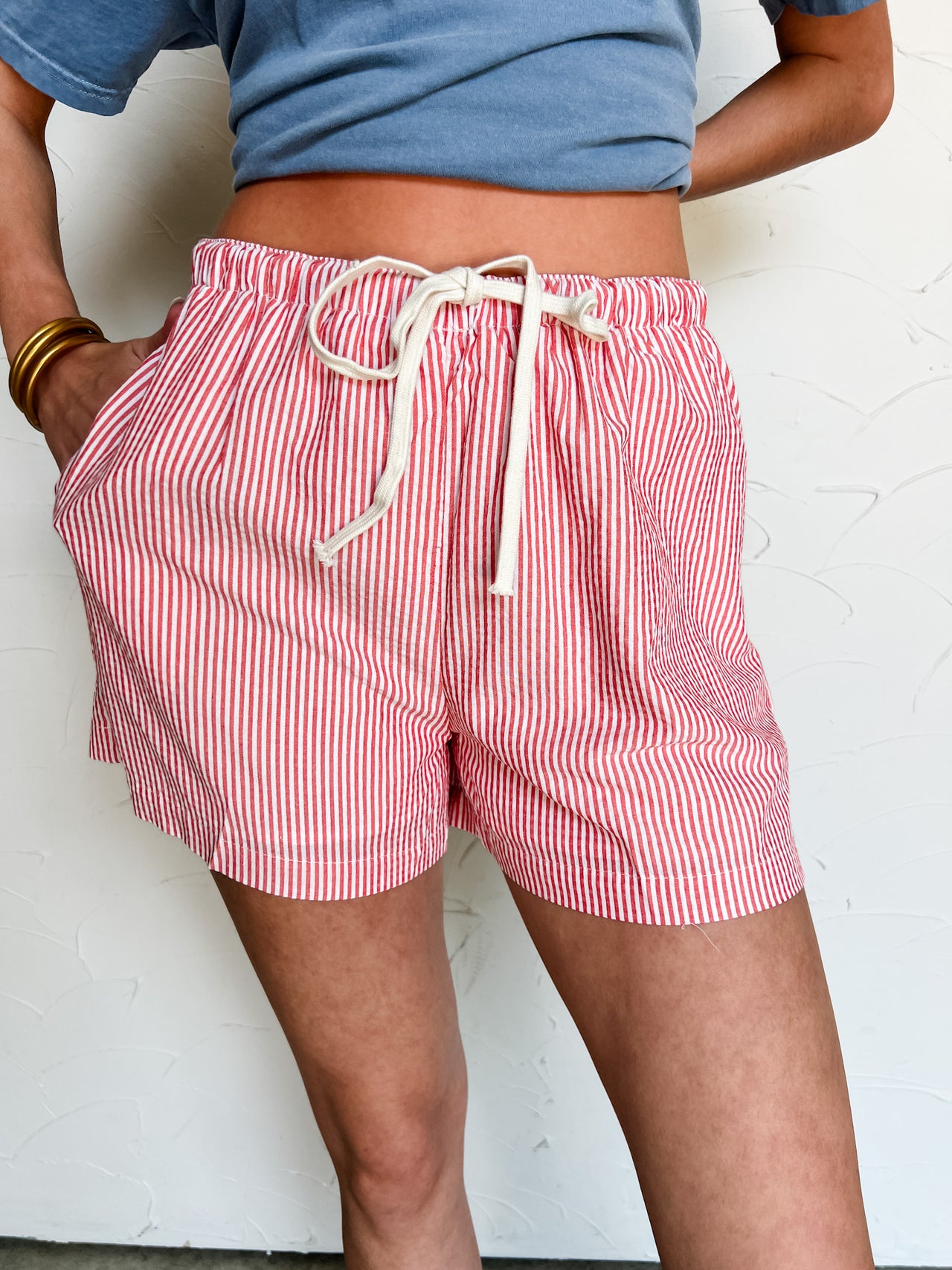 Person wearing red and white striped shorts with a plain background