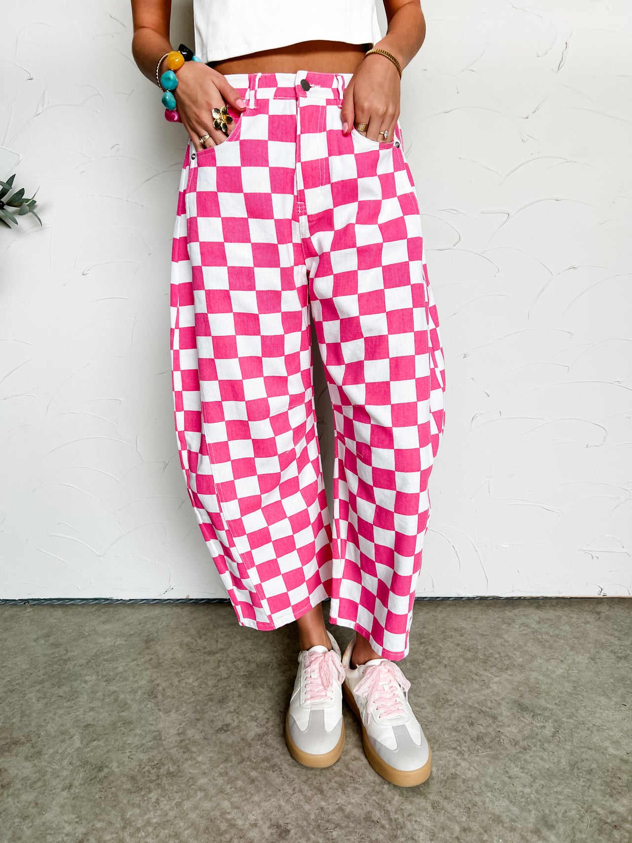 Person wearing pink and white checkered pants with a white background