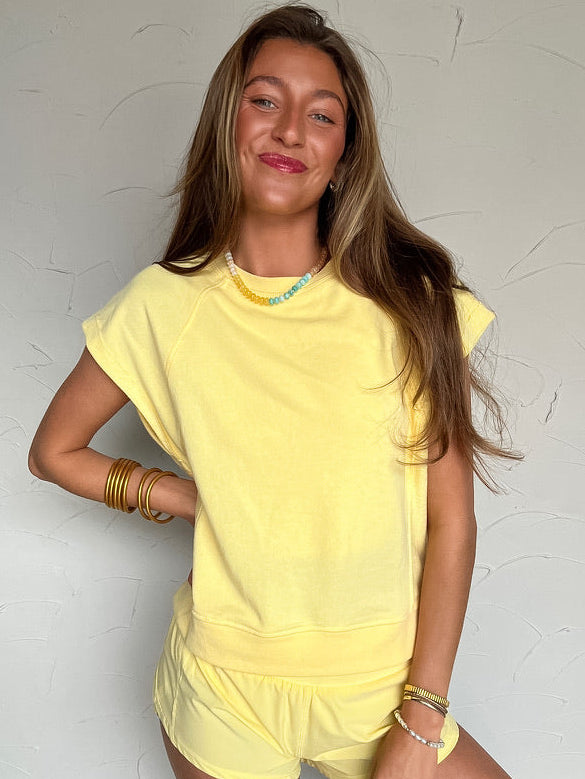 woman wearing a yellow short sleeve and short matching outfit 