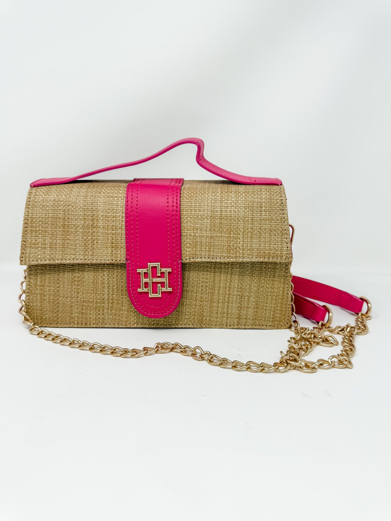 Woven handbag with pink strap and gold chain on a white background