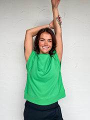 Girl wearing a green t shirt in front of plain background 