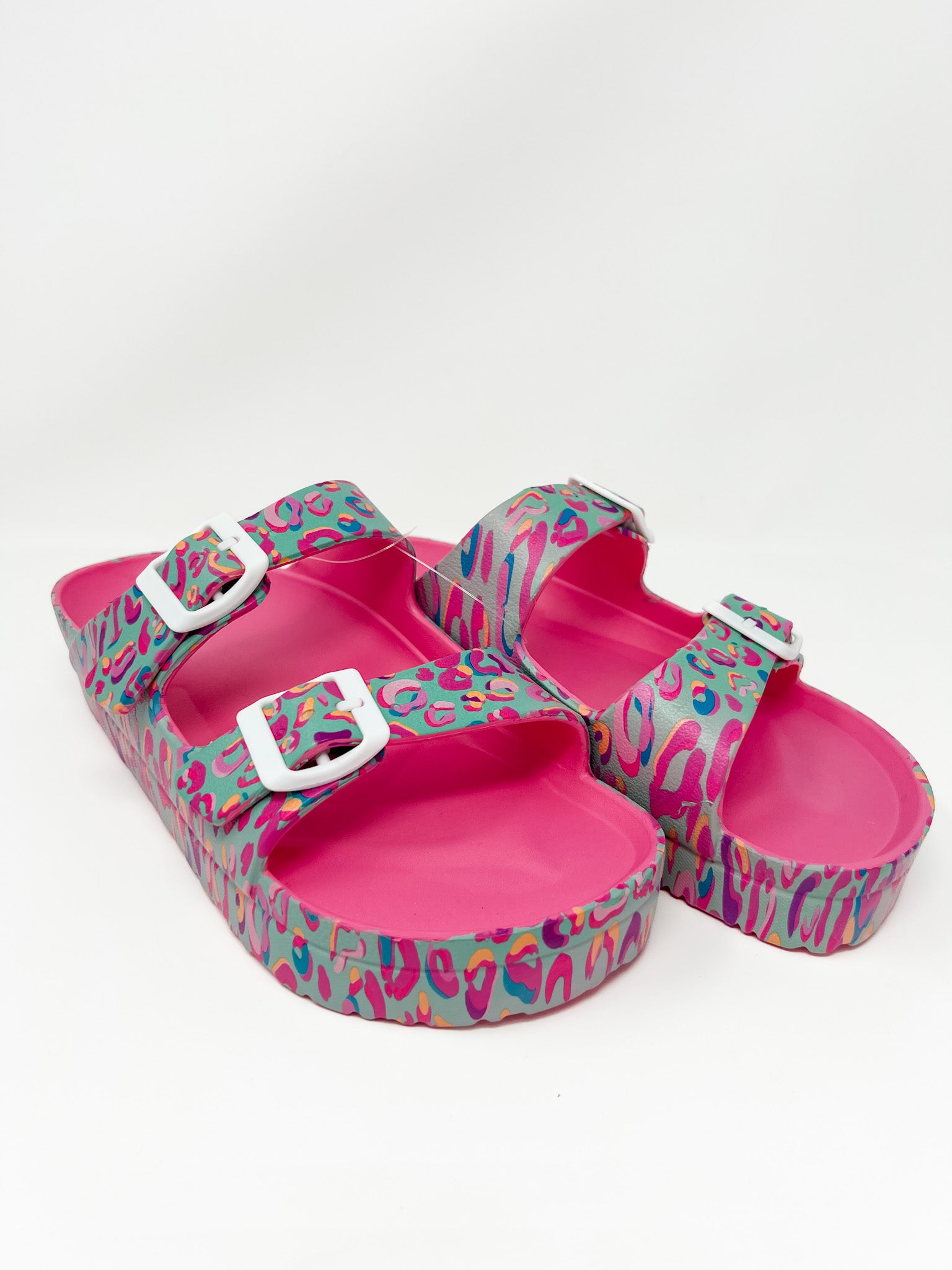 Cheetah print multi color sandals on a white wall