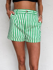 Green and white striped shorts worn by a person on a white background