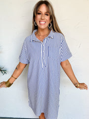 Woman wearing a blue and white striped t-shirt dress against a white background