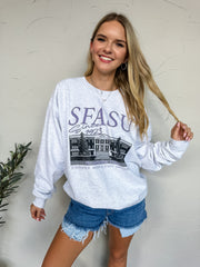 Woman wearing a white sweatshirt with 'SFASU' text and graphic, standing against a plain background.