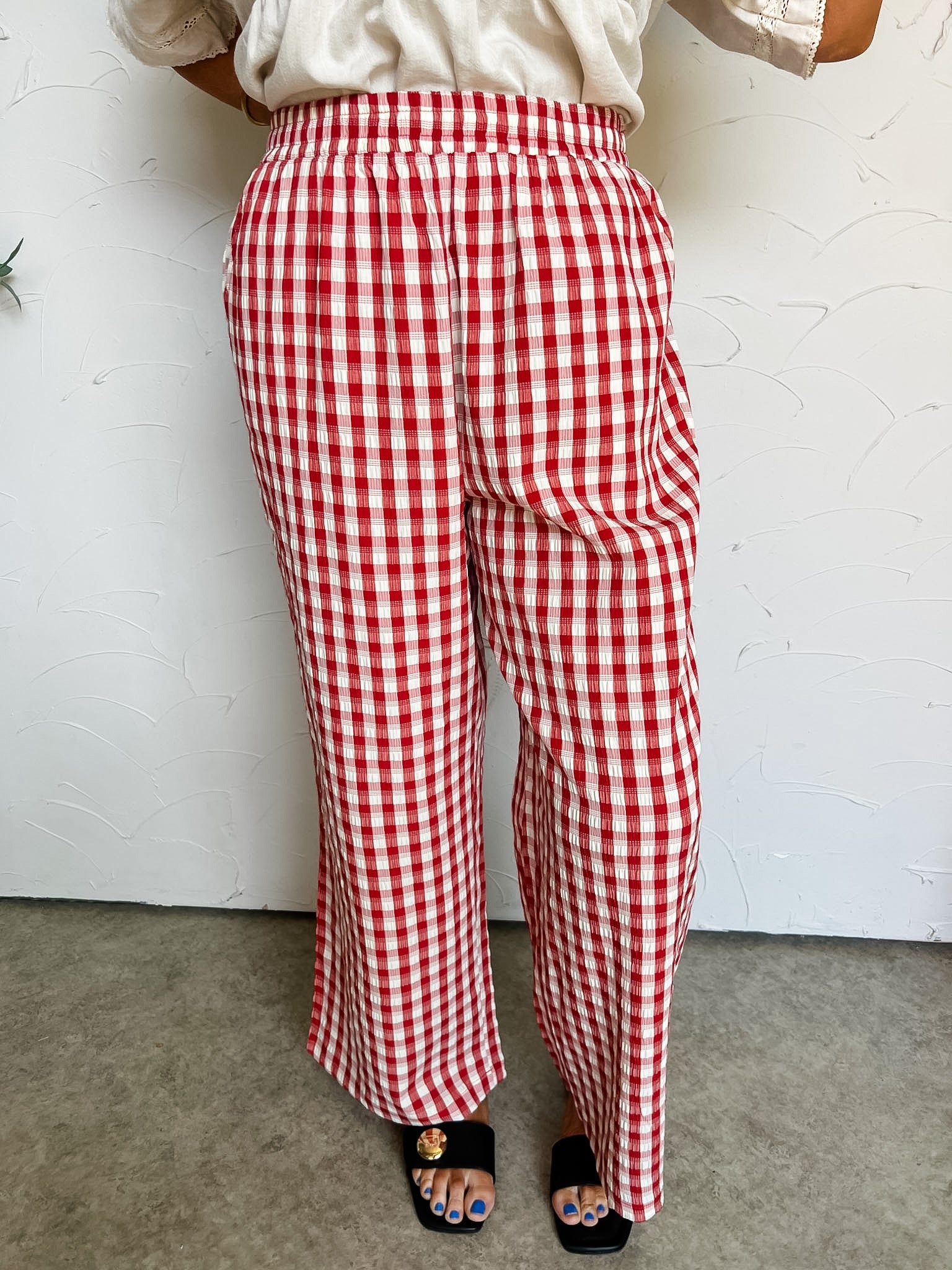 Red and white checkered pants worn by a person on a plain background