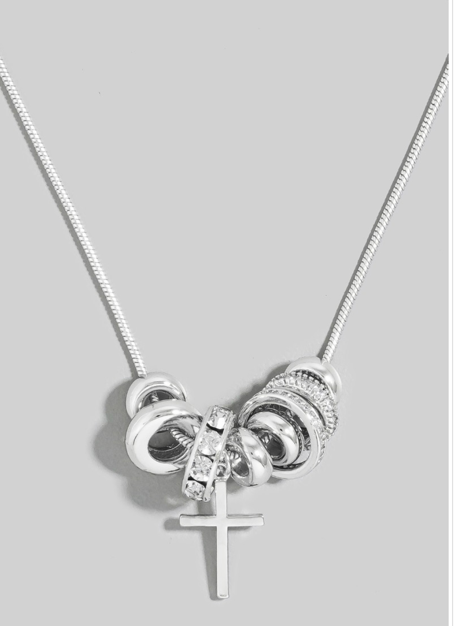 Silver necklace with interlocking rings and a cross pendant on a light gray background