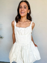 Woman wearing a white dress against a plain background