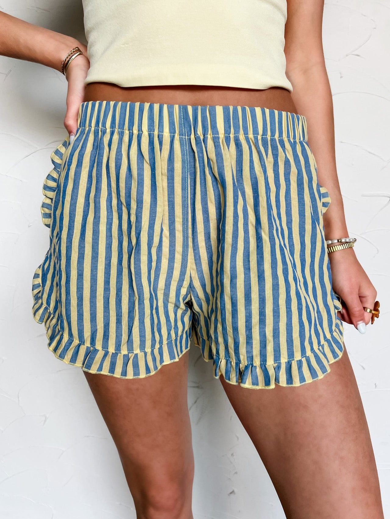 Person wearing blue and yellow striped shorts on a white background