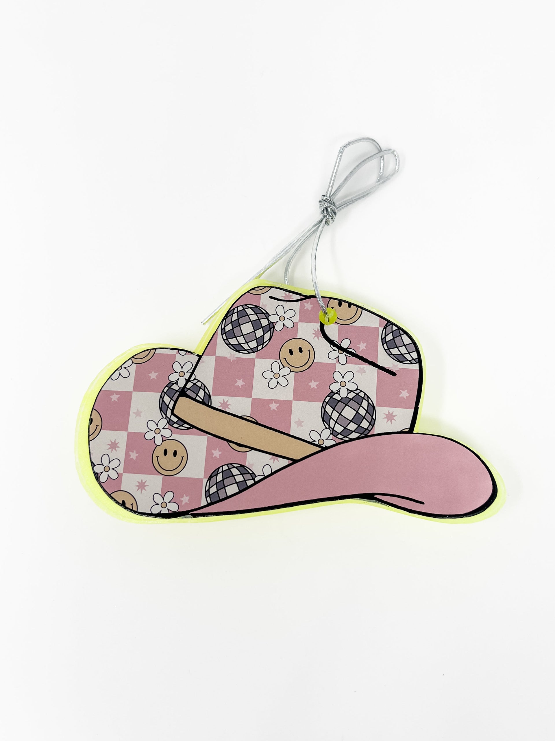 This cowboy hat car freshie features a fun, western-style shape decorated with vibrant graphic patterns and a contrasting colored brim. It comes ready to hang from your rearview mirror with an attached hanging hook. Colors and scents vary.