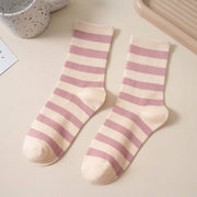 Pair of pink and white striped socks on a light surface.