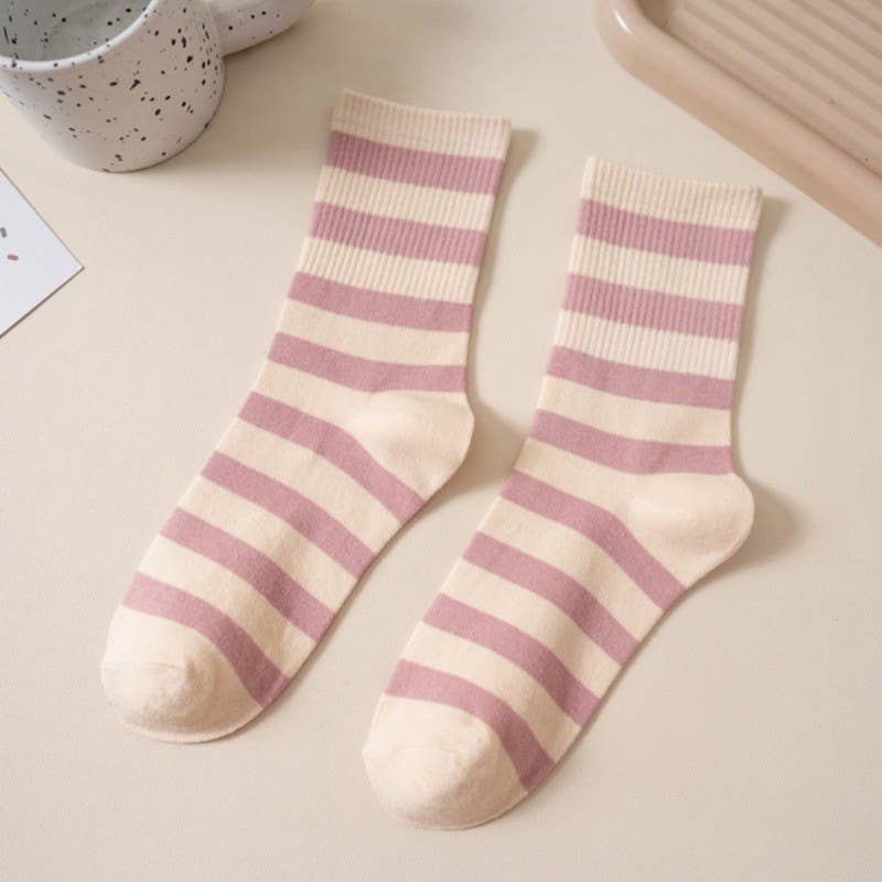 Pair of pink and white striped socks on a light surface.
