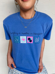 Girl in blueberry festival shirt in front of plain wall 