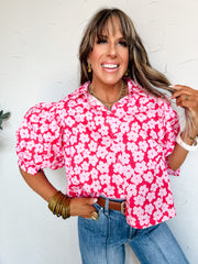 Woman wearing a pink floral blouse against a white background