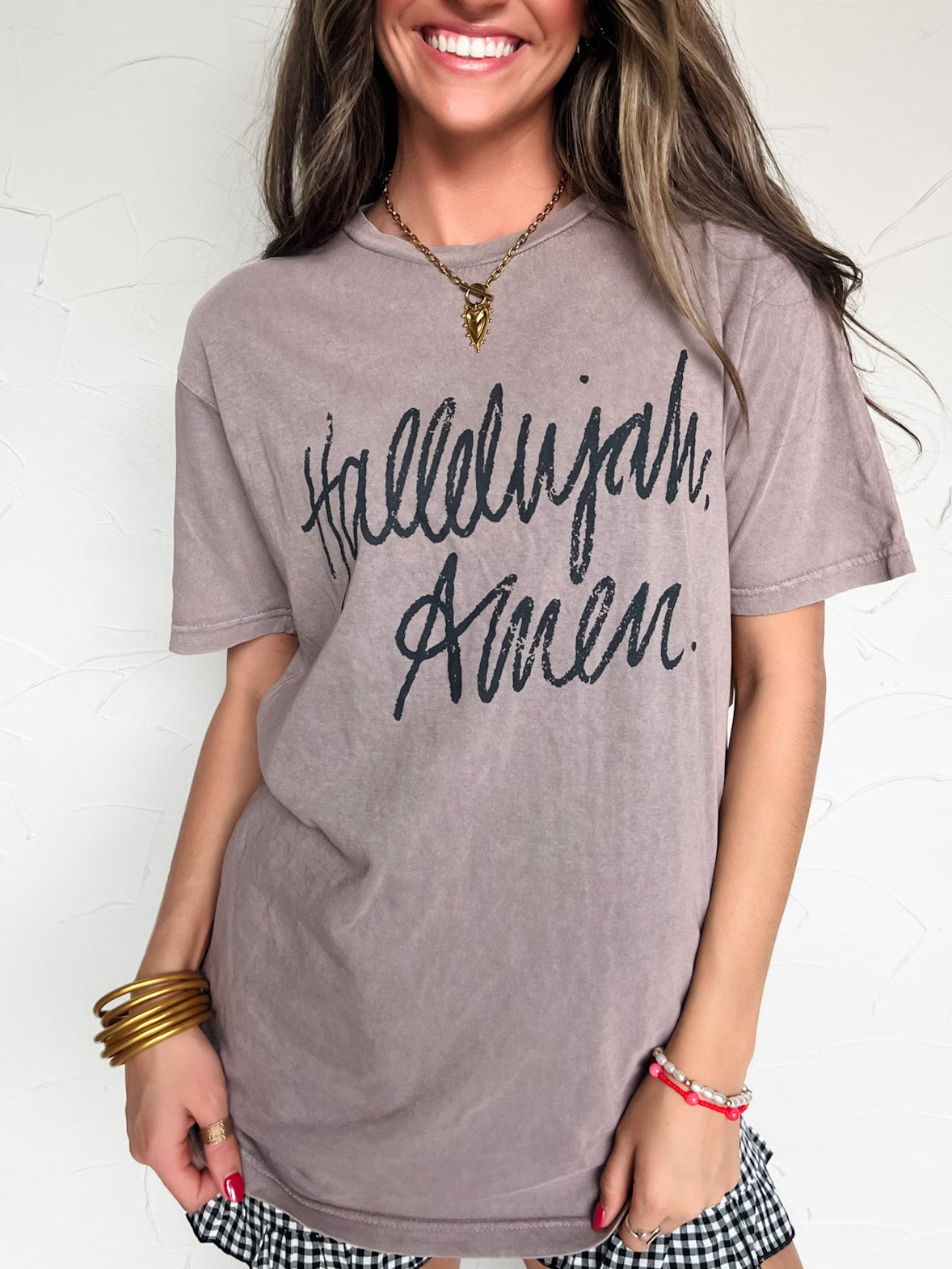 Woman wearing a gray t-shirt with 'Hallelujah Avenue' text against a white background