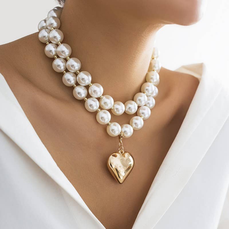 Pearl necklace with a gold heart pendant on a mannequin