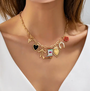Necklace with various charms on a mannequin with a white background
