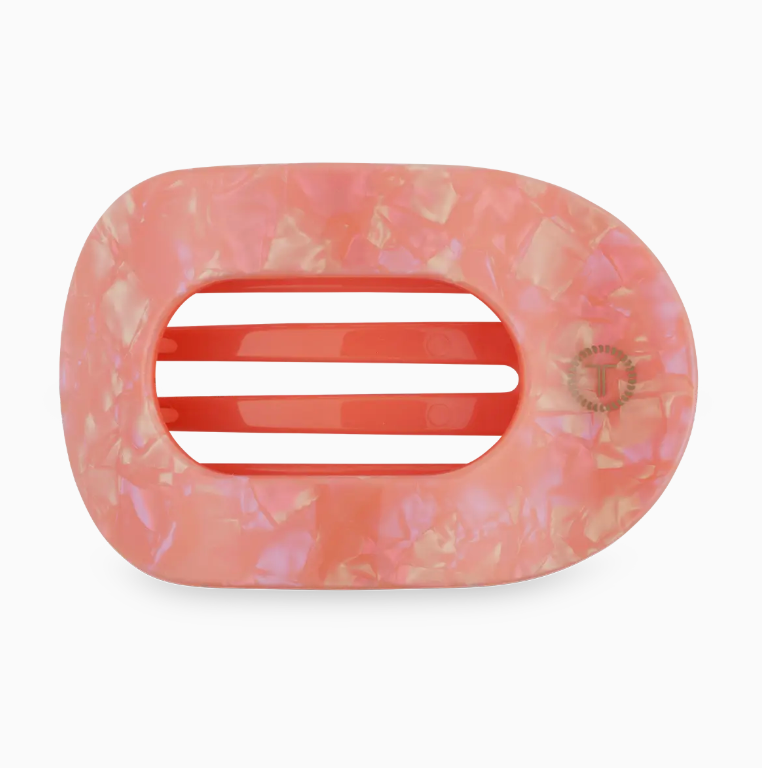 Orange marbled patterned hair clip with a white center on a white background