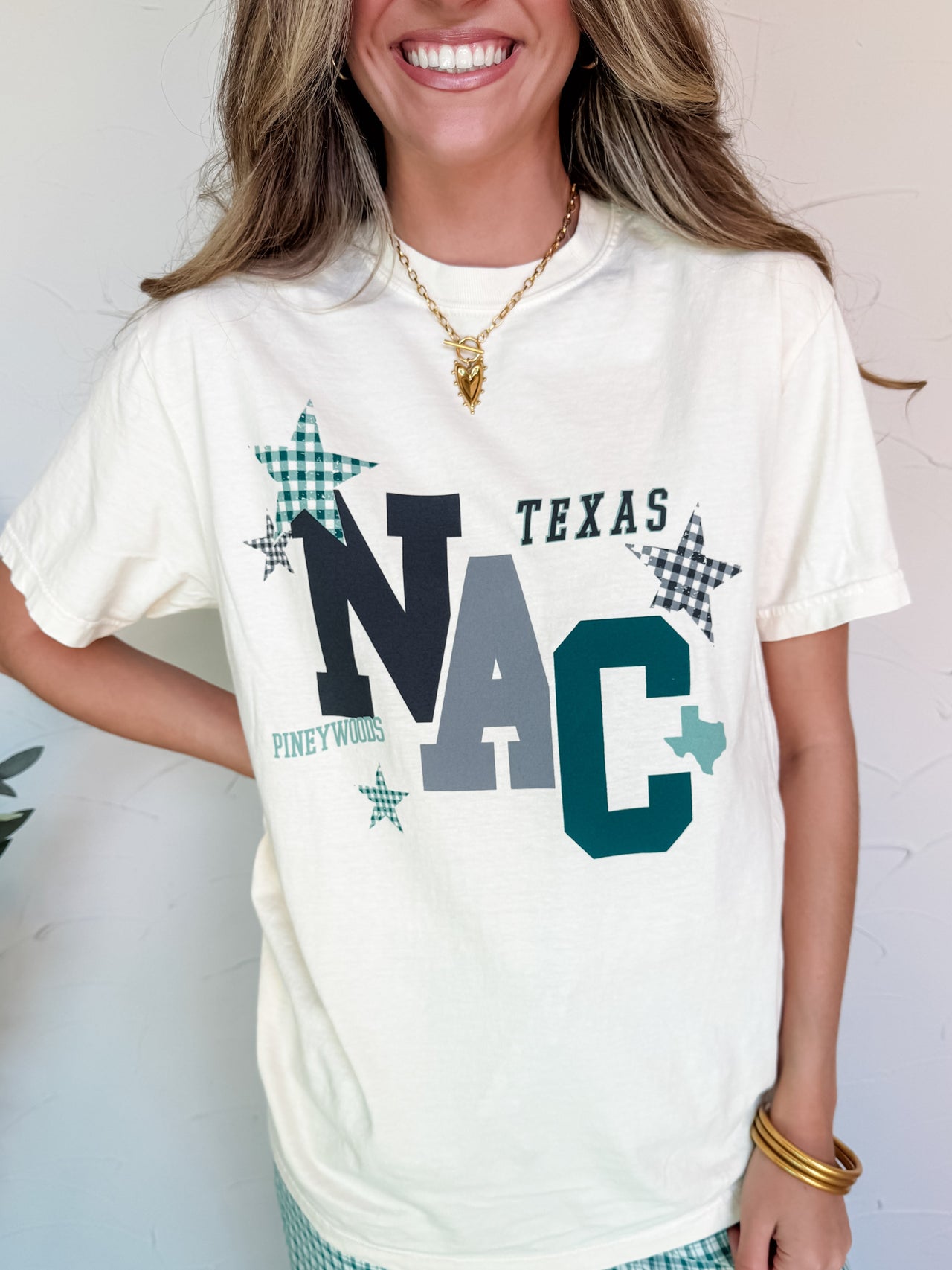 Woman wearing a white t-shirt with 'Texas NAC' text and graphics.