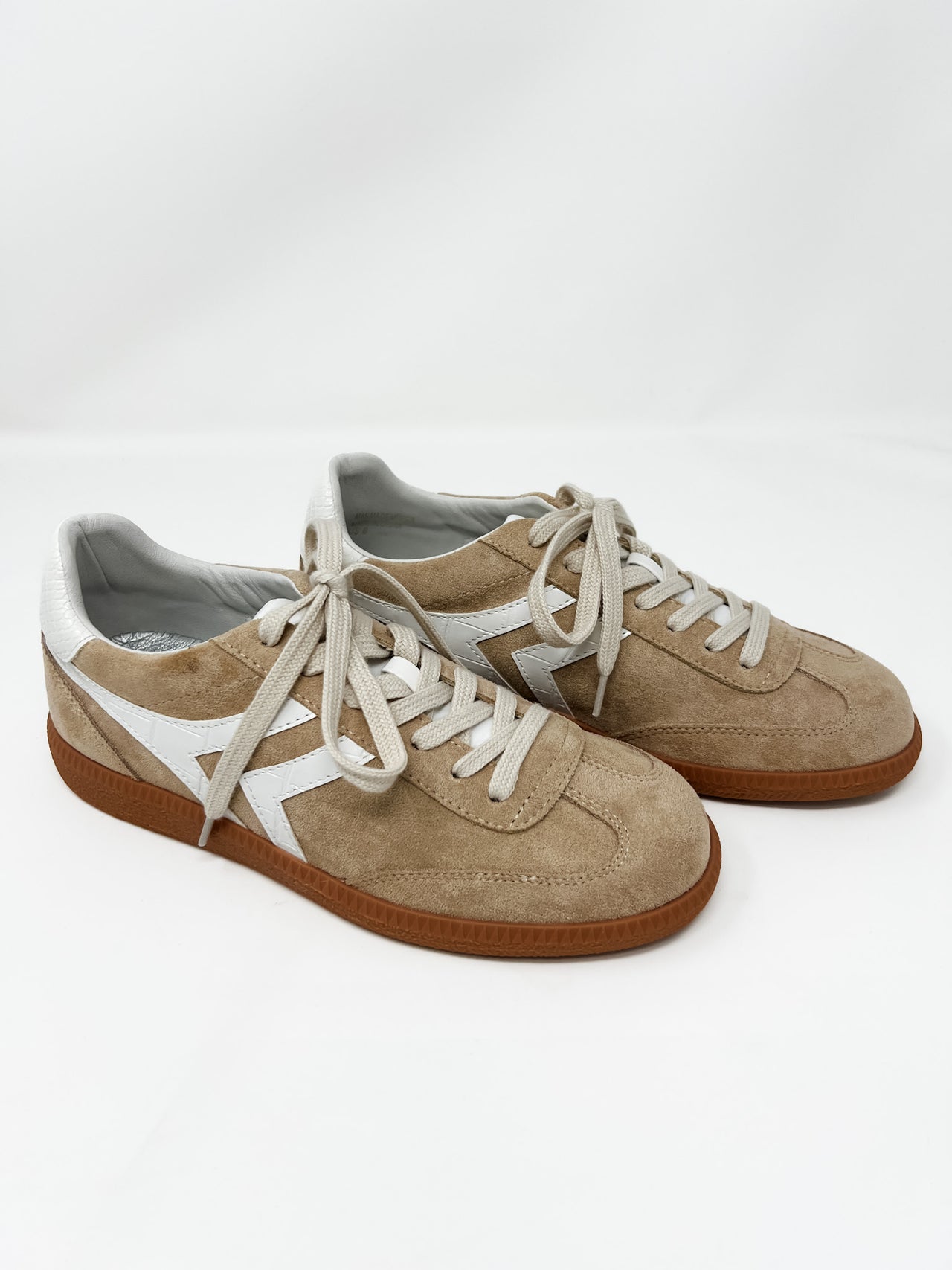 brown suede low top sneaker with a white leather detail on the sides to match the back. Rubber dark brown sole to contrast light brown suede. 