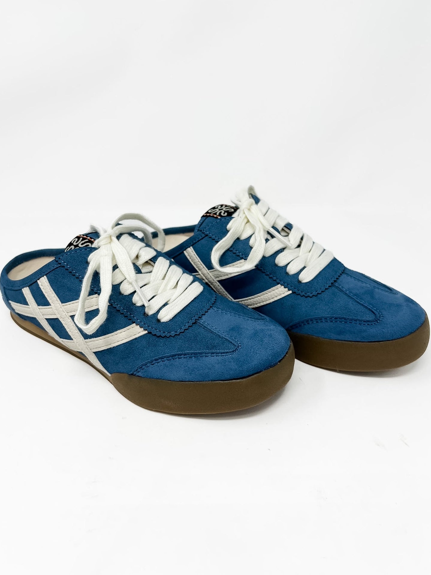 Blue slide on sneakers with white laces on a white background
