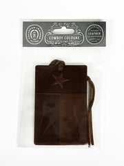 Brown leather air freshener with star design on a white background, featuring 'Cowboy Cologne' packaging.