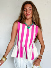 Woman wearing a pink and white striped sleeveless top with white shorts, holding a yellow handbag with floral design.