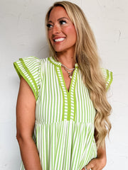 Woman wearing a green and white striped dress against a white background