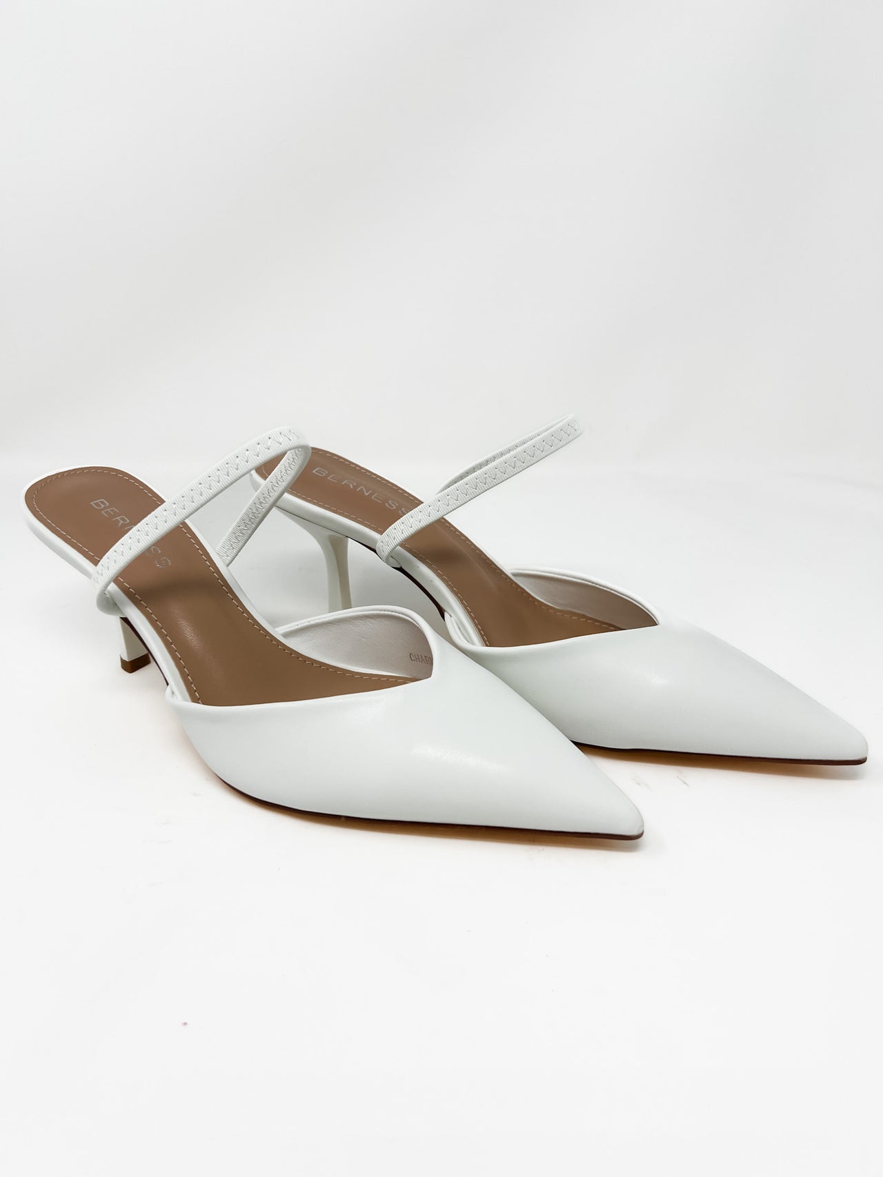 White pointed-toe heel with thin straps on a white background