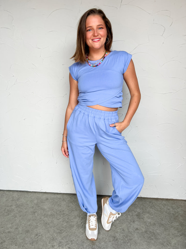 Girl in blue matching set in front of plain wall 