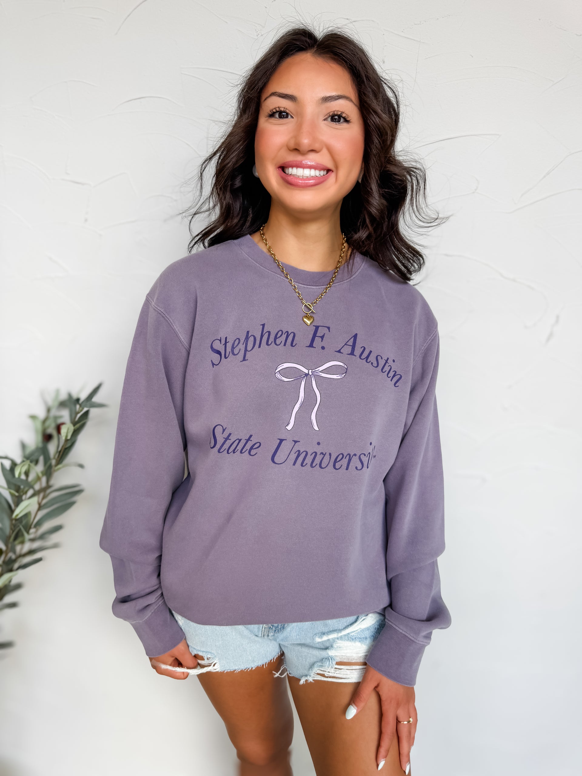 Woman wearing a Stephen F. Austin State University sweatshirt against a white background