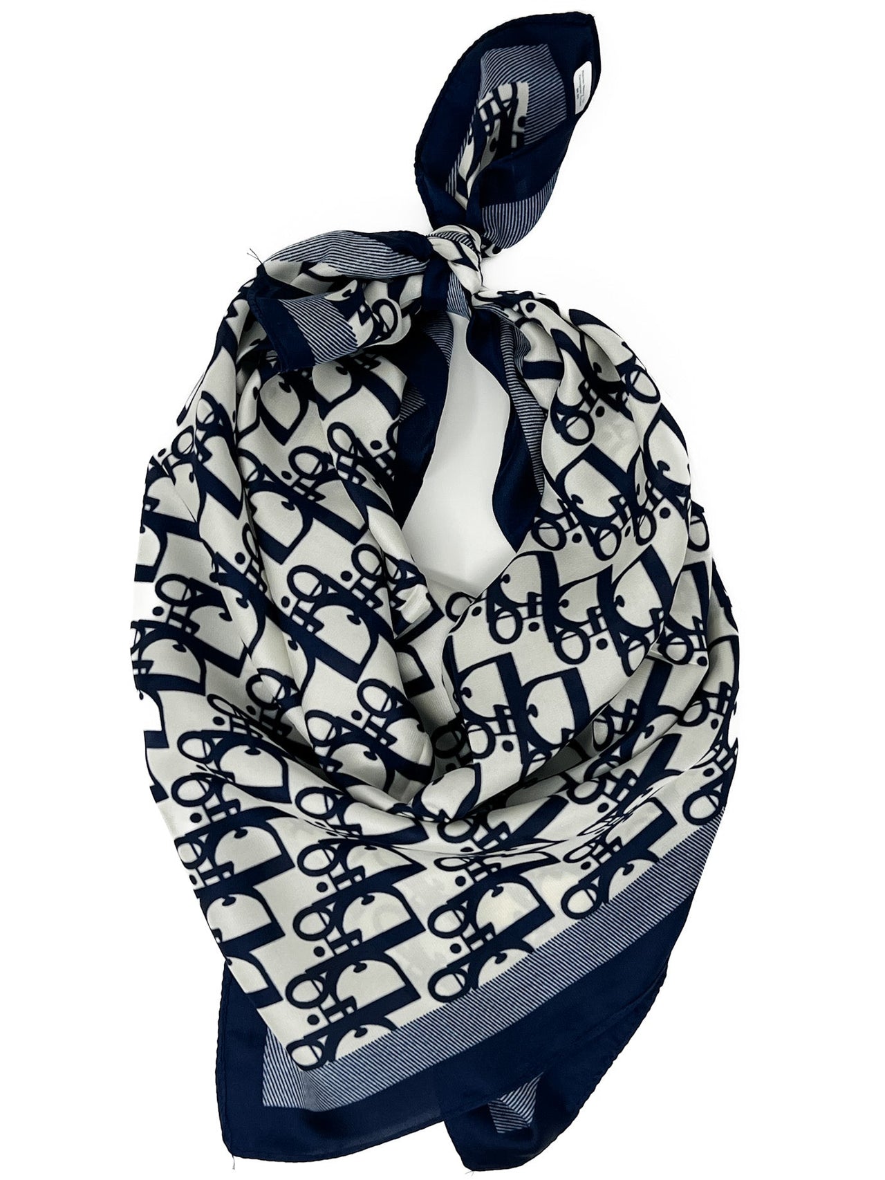 Navy and white patterned scarf tied on a white background