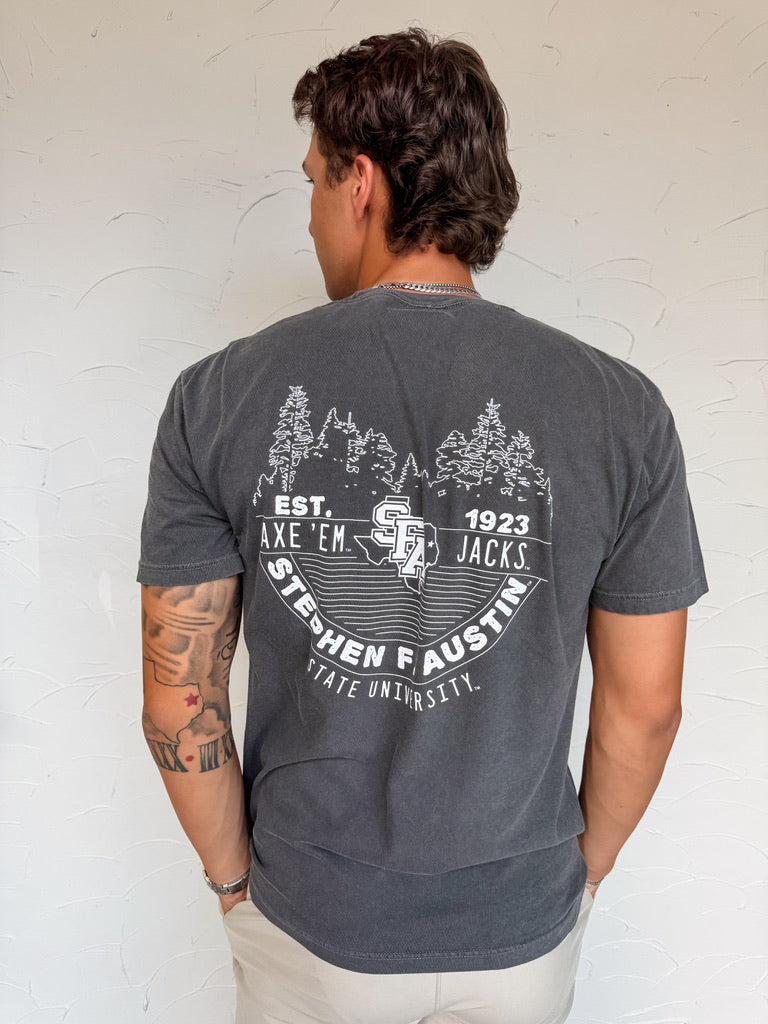 Man wearing a gray t-shirt with a graphic design on the back against a white wall.