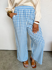 Person wearing blue and white checkered pants against a white background